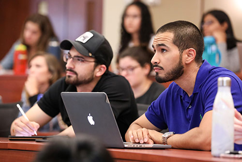 two male nursing students sitting in a classroom